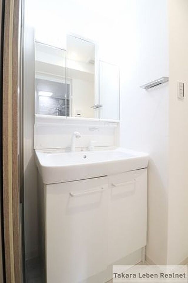 洗面室。洗面台下には収納スペースがございますので、アメニティやタオル類の格納としてお使いになれます。