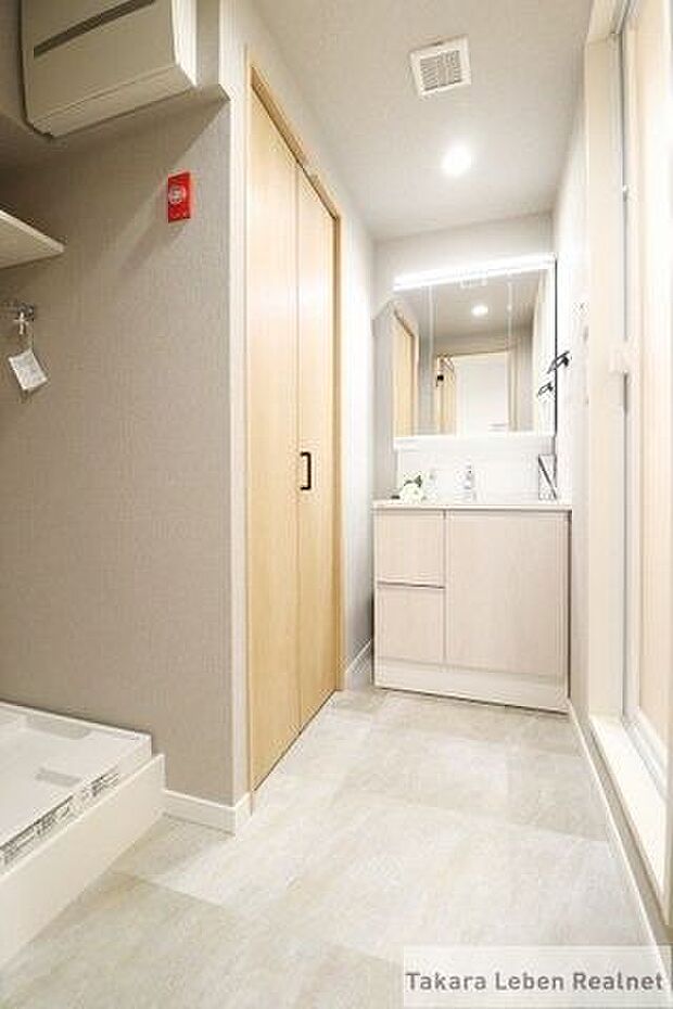 ゆとりのある洗面スペース。洗面化粧台の左側壁面には収納スペースがあります。