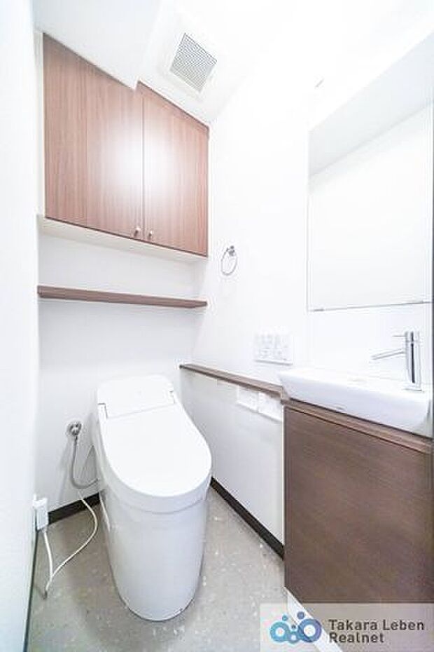 木の温もりと白を基調に清潔感のあるトイレ。上部に吊戸棚があり、掃除用具などの収納場所に困りません。手洗い場と鏡が設置されているのは嬉しいですね♪
