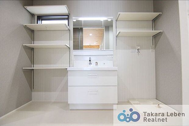 鏡裏にも収納可能な三面鏡洗面台。サイドに空間を有効活用した、位置を調節できる可動棚、洗濯機置場上部にも棚を設けています。