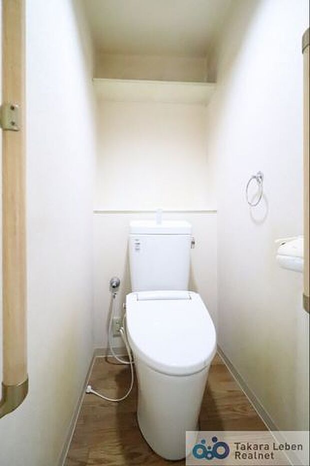 ウォシュレット機能付きのトイレ。タオルハンガー、トイレの立ち上がりに便利な手すりが標準装備しています。壁面に棚が設置されているので、備品の収納もできますね！