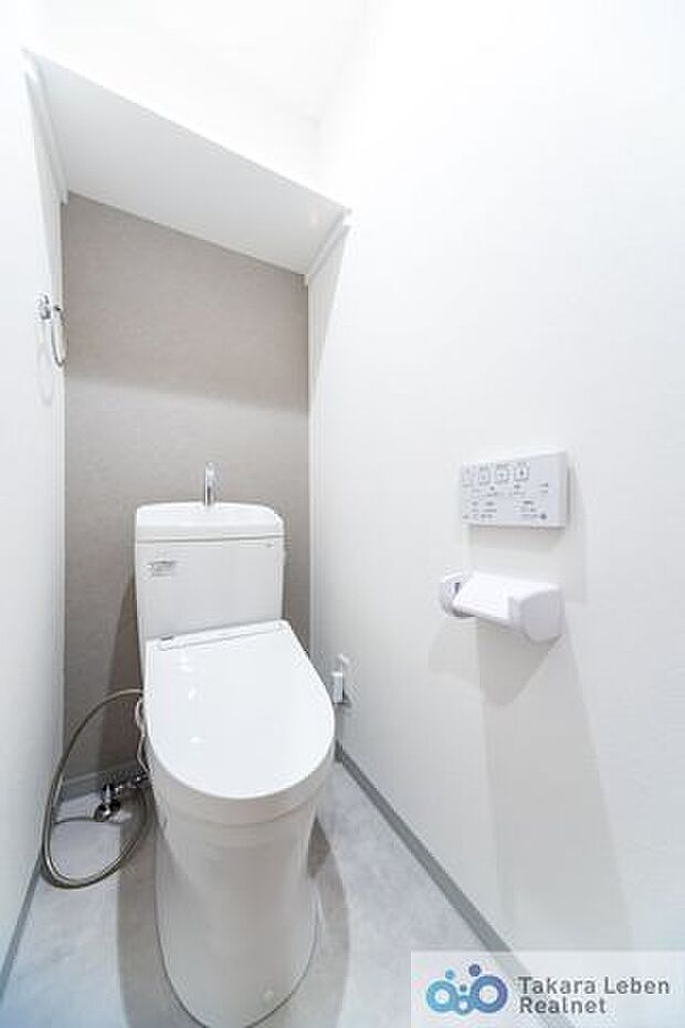ウォシュレット機能付きのトイレ。トイレットペーパーホルダーとタオル掛けは標準で実装してます。