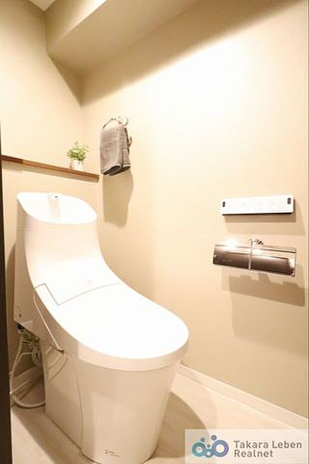 温水洗浄トイレのリモコンは、操作がしやすい壁掛けタイプ。ペーパーホルダーには2ロール設置可能です。
