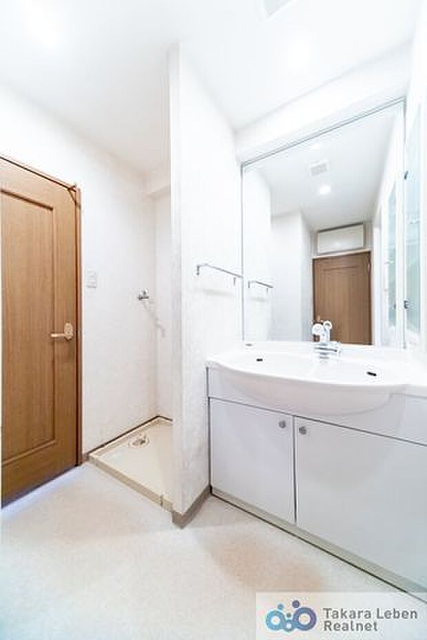 大きな鏡と、ゆとりのある洗面ボウルが魅力です。洗面化粧台の右側壁面には収納棚があります。アメニティやタオル類の格納としてお使いになれます。