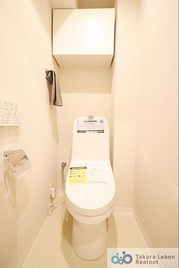 白を基調に清潔感のあるトイレ。トイレットペーパーホルダーとタオル掛けは標準で実装してます。ウォシュレット機能は壁掛けリモコンの上位グレードを採用しました。