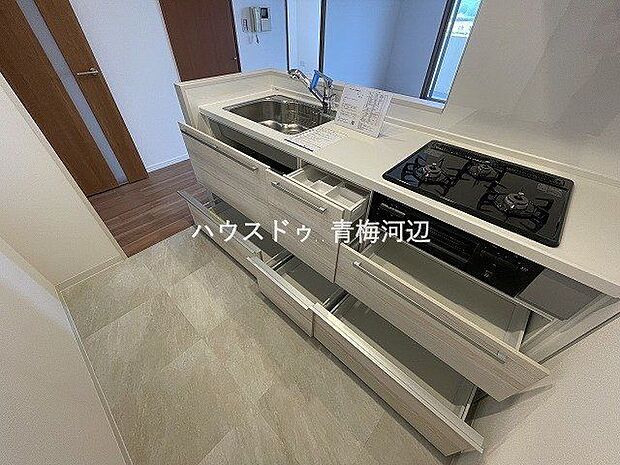 ホワイトで統一された爽やかなキッチンスペースです。収納スペースもありますので調理器具も片づけられます。三口コンロ付きでお料理がはかどりそうです。