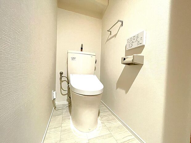 温水洗浄便座付きの清潔感あるトイレは、落ち着いた空間に。収納棚が設置されており、床にストックを置く必要がなく掃除も楽々。