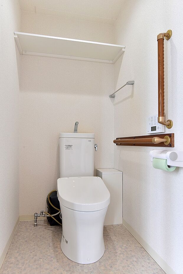 立ち座りなどの動作の補助に効果的な手すり付きのトイレ。温水洗浄便座付きで快適空間。