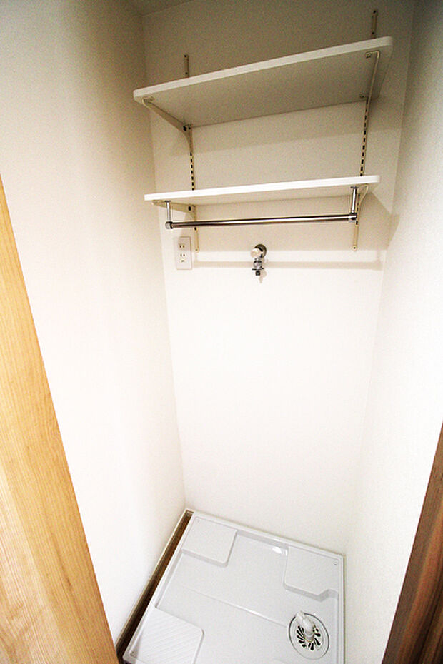 扉付きの洗濯機置場あり。洗面室に入れてしまうとスペースが取られてしまうためにあえて別スペースに設置