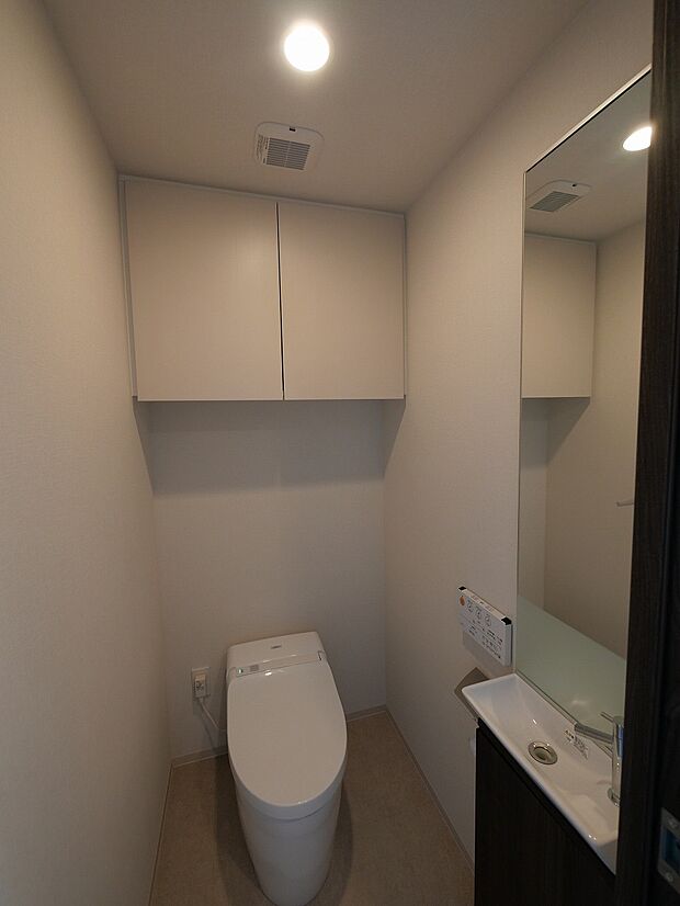 上部吊戸棚付き、手洗いカウンター付きのトイレ