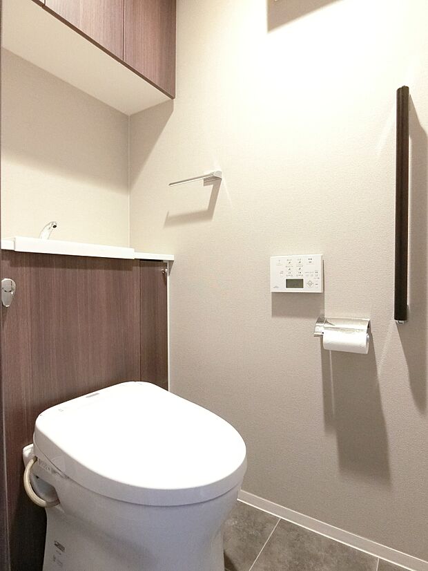 収納に便利な吊戸棚付きトイレ、フタは自動開閉設定が可能です。
