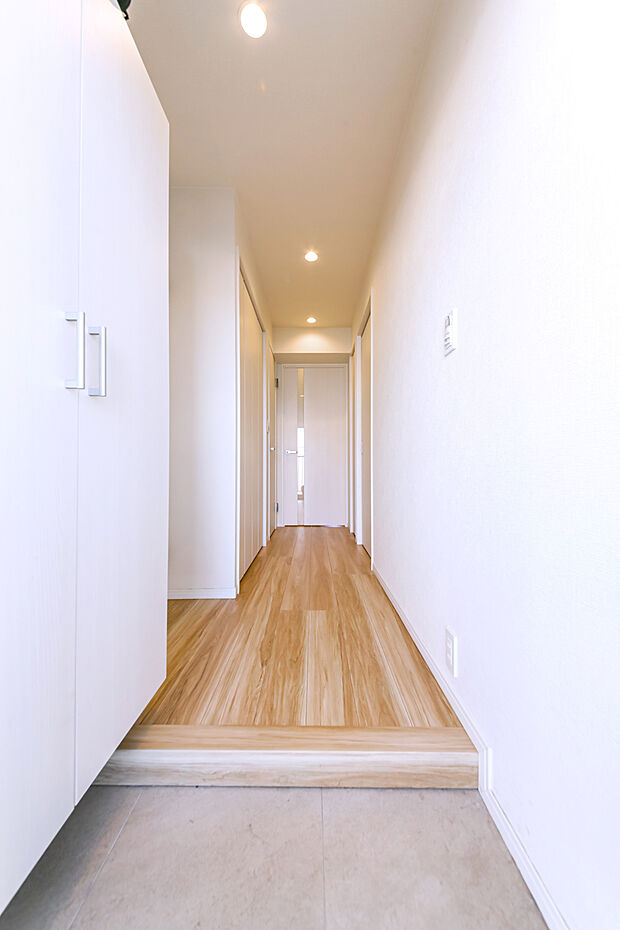 白い壁面と木目の床のコントラストのある廊下