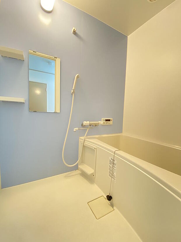 【浴室】明るい水色の壁紙がアクセントになり、リラックスバスタイムを過ごせます。ボタン１つで決まった量のお湯を張ってくれるお湯張り機能付です。シャンプーなどを置けるボトルラックも備え付けられています。