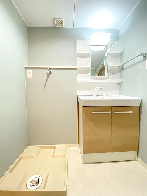 【洗面室】明るい洗面台で毎朝の支度もはかどりますね。鏡横と洗面台下に収納スペースが設けられており、すっきりとした空間を保つことができます。出入りのしやすい引き戸のため空間を有効に活用できます。