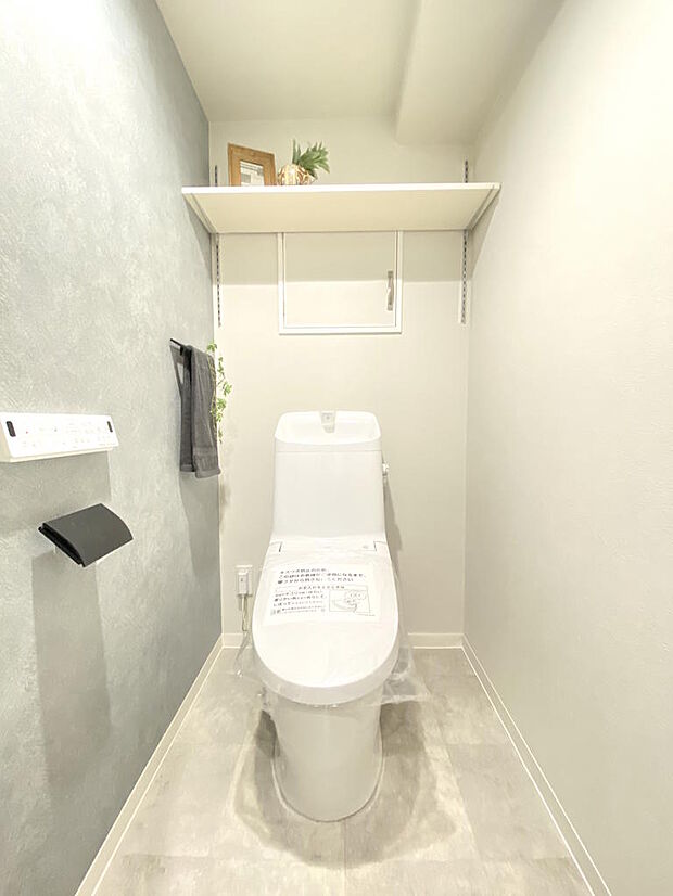 【トイレ】トイレットペーパーやお掃除グッズなど収納できる棚があります。壁、床、天井など全体が白色に統一されていて、清潔感のある空間です♪温水洗浄便座つきトイレで、座った時にヒヤっとせず快適です。
