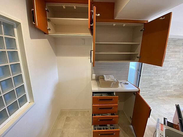 【キッチン収納】広々としたシステムキッチン背面には、備付けのカップボードがあります。上下に収納たくさんあり、食器や調理用具だけでなく、食品のストックなどもすっきりと片付けられ助かりますね。