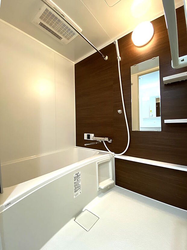 【浴室】新調されたバスルームは、落ち着いた木目調の壁紙が印象的です。リラックスバスタイムを過ごせて毎日の疲れも癒されます♪シャンプーやボディソープなどを置けるボトルラックも備え付けられています。