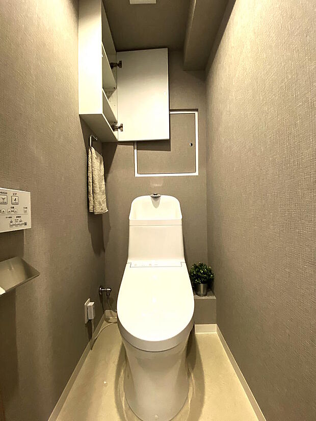 【トイレ】手洗い・温水洗浄便座付きで、座った時にヒヤっと冷たくならず快適なトイレ時間が過ごせます。お掃除しやすいタンク一体型のトイレです。トイレ奥左側には、扉付き可動２枚棚の収納がついています。