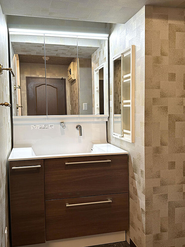 奥行きのあるシャワー付洗面化粧台。左右の鏡は折戸となっており手前に引き寄せ可能。右側には埋込収納あり。