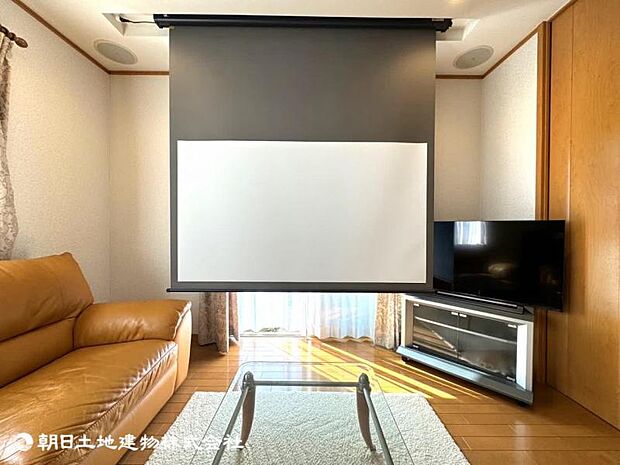 埋め込み式スクリーンのホームシアターをリビングに設置、自宅にいながら映画館のような映像とサウンドを楽しめます。