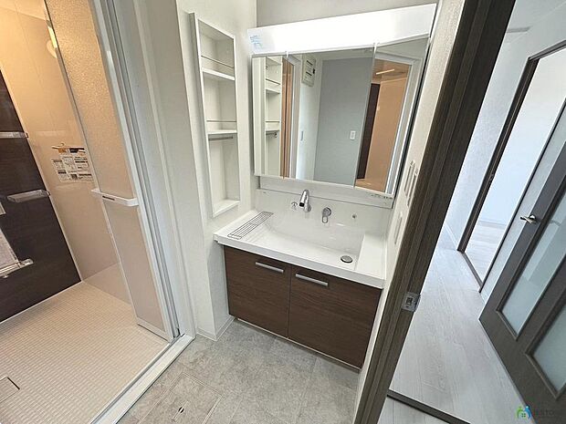 【洗面所】使いやすい三面鏡の中やベースキャビネットには収納スペースもたっぷり。手入れしやすいシャワー機能付。開放感ある空間と、十分な大きさの鏡も自慢です