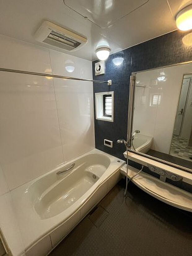 大きな鏡が特徴的な浴室です。換気に便利な小窓もついています。