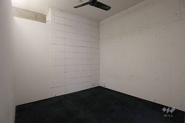 南側の洋室。素足で入ることの多い寝室は肌触りのよいカーペット。白に塗装されたコンクリートブロックがアクセント。