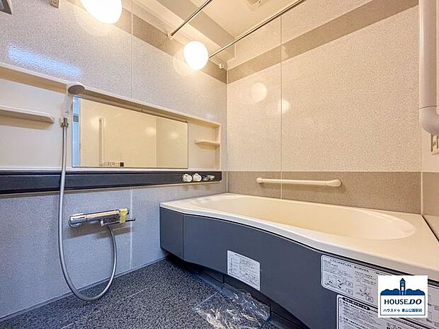 清潔感ありシックな内装の浴室。浴室鏡は室内の広さをより感じやすい横向きに設置されています