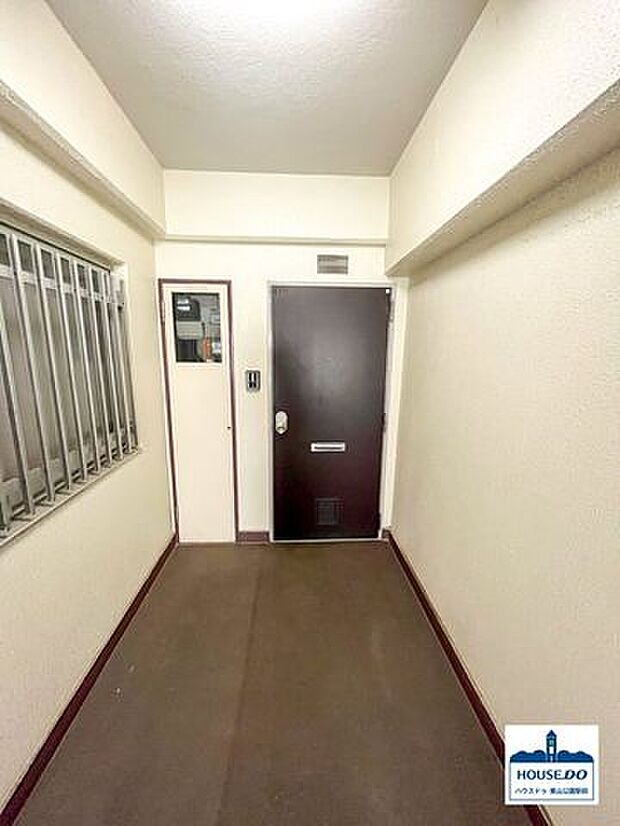 共用部廊下より少し奥まった位置にある玄関扉