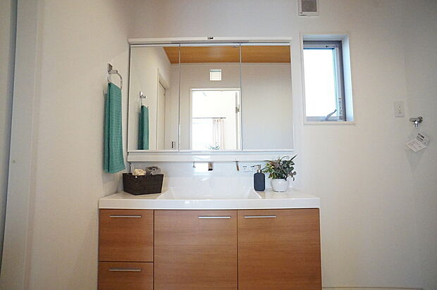 収納力が高く、シンプルなデザインの大型洗面台が備えられた洗面所