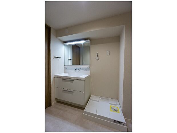 限られたスペースでスッキリ見せる洗濯機置き場。家事導線にも配慮されています。