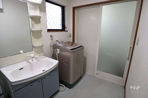 洗面室。回遊導線の洗面室で家事がしやすいです。洗面室は広く、洗面台左手には収納を置くスペースもあります。窓があり、風通しのよい洗面室です。
