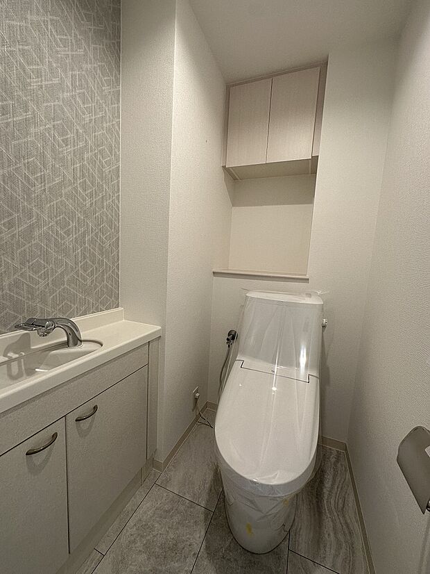 トイレには手洗い器が設置されております。上部に棚がございますので、ペーパー類の保管にも便利です。