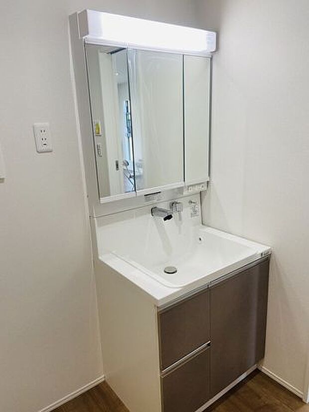 お掃除楽々　壁付け水栓洗面台です。三面鏡で鏡も広く、収納スペースもしっかりと確保されています。