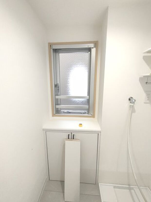 ・洗面室　　採光が取れる小窓と、ストックの収納に便利な棚が造作されています。