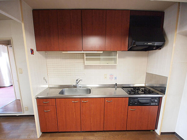 【キッチン】空間を有効に活用できる壁付けタイプのキッチンが採用されています。吊り戸、シンク下には調理道具等を収納でき、生活感をすっきりと隠せます。