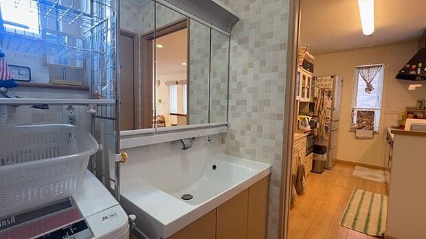 【洗面所】立派な三面鏡付き洗面化粧台のついた洗面所です。キッチン・廊下から行き来ができます。
