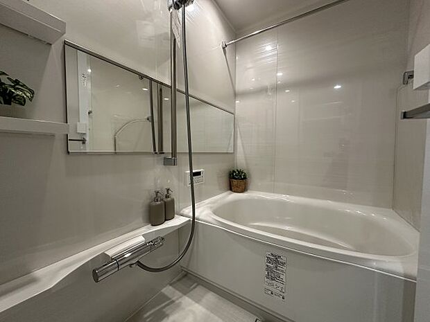 白を基調としたバスルームで、清潔感溢れる空間に！奥行を感じるワイドミラー採用。