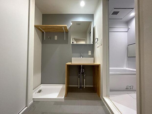 壁に施された爽やかなブルーグレーのアクセントクロスと、パイン材を使用したナチュラルな木材が良く合う、シンプルながらも印象的な洗面脱衣室です。