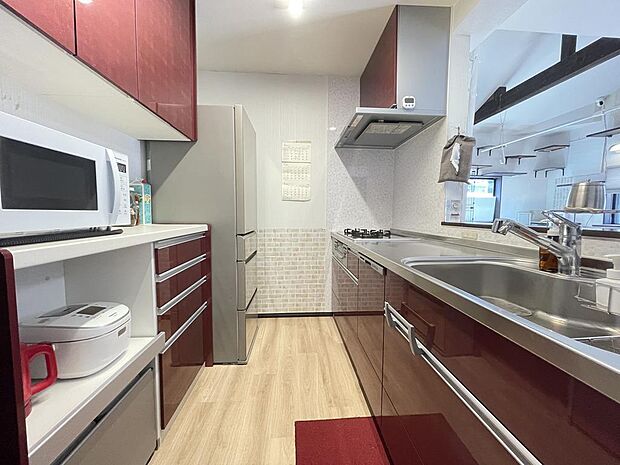 赤がスタイリッシュなキッチンには、造り付けの食器棚があります。スペース広くお料理も捗りますね。
