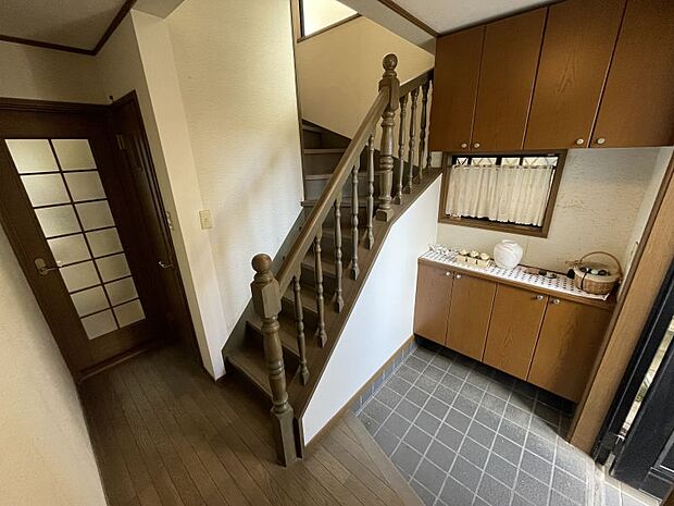 茶色を基調とした落ち着いた雰囲気の玄関です。階段の手すりが格子状で開放感のある空間です！