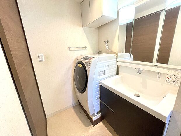 洗面台は三面鏡と鏡ウラの小物収納も設置。屋内洗濯機置き場もあります。
