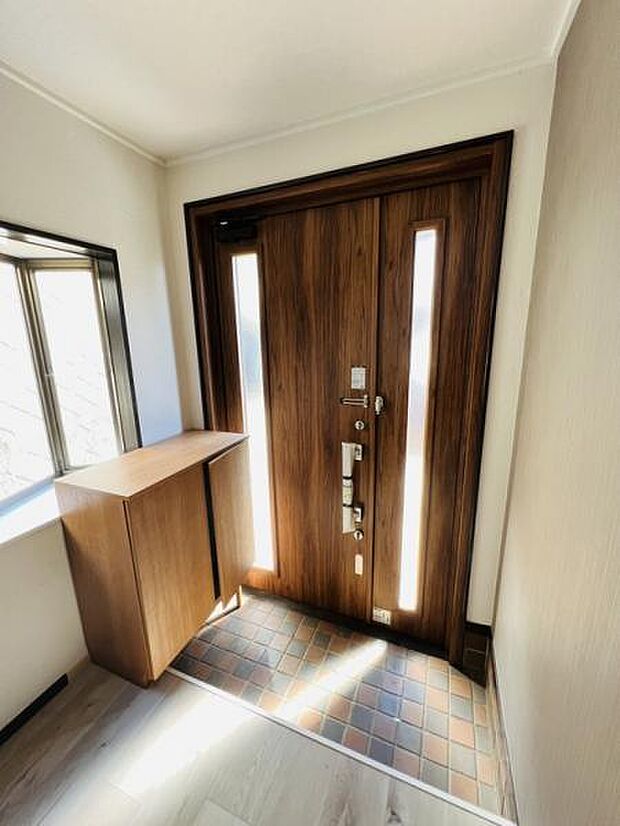出窓とスリット窓の2方向からの光で明るい印象の玄関スペース。