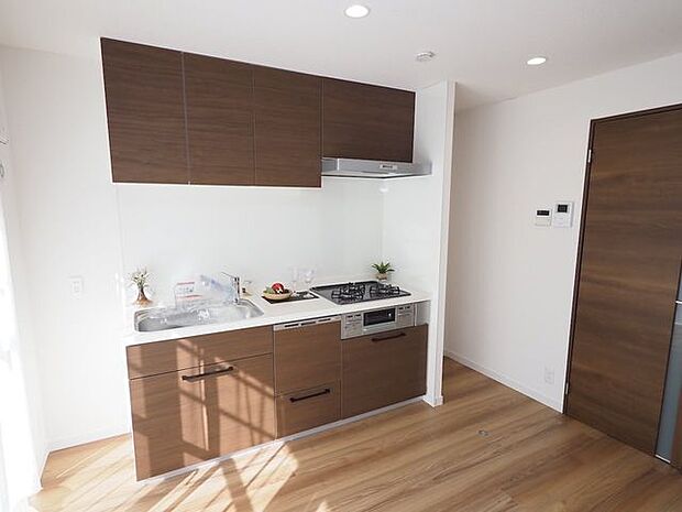 壁付キッチンになります。キッチン下部、上部の2か所に収納がある為、食器棚を置かなくとも、十分な収納力を持ち合わせたキッチンです。また、壁付することでリビング・ダイニングのスペースを広く活用できます。
