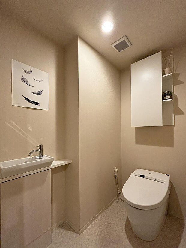 手洗い器、吊り戸棚付きのゆとりあるトイレ
