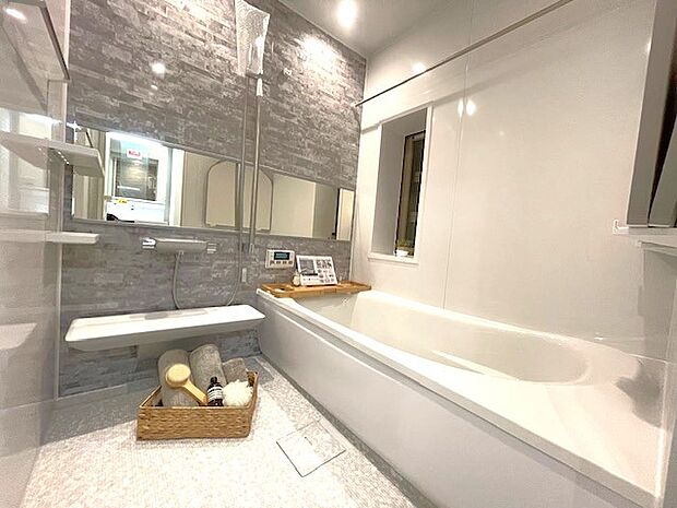浴室は白を基調とした中に、オシャレなグレーの壁を採用することで、明るい上で落ち着く空間を実現しております。日々の疲れをこちらの浴室で癒してくださいませ。