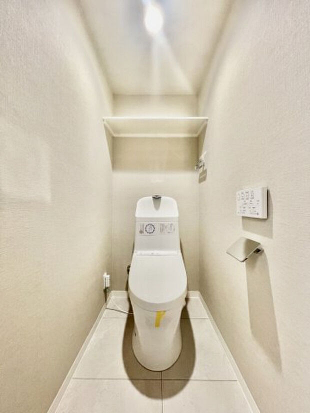 白を基調とした清潔感を感じるトイレ♪背面に棚を設置して、トイレットペーパー収納にも便利◎