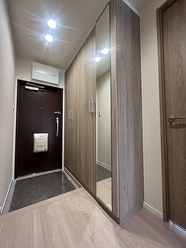 容量たっぷりの玄関収納には全身鏡を設置済。デッドスペースを作らない平面的なデザインがポイントです。