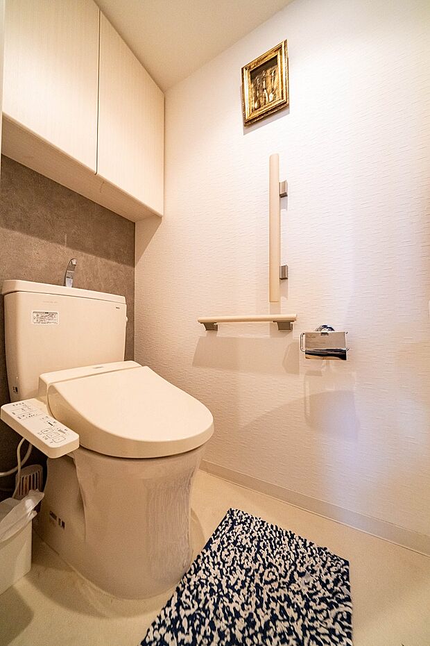 快適な温水洗浄便座付きのトイレ。モルタル調のアクセントクロスが、落ち着きを感じる空間を演出します。