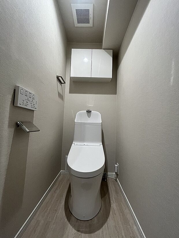 清潔感溢れる温水洗浄便座付きのトイレです。上部に棚があり、トイレ用品がスッキリ片付きます。